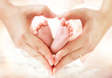Making Memories: a loving moment with a parent's hands forming a heart around a baby's tiny feet.