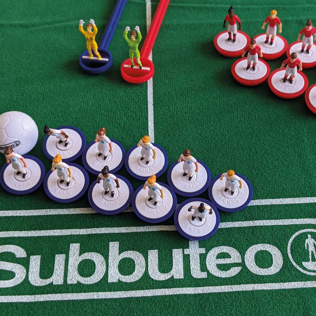 Subbuteo Lionesses Main Game with player figurines on a green pitch featuring the Subbuteo logo.